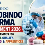 Aurobindo Pharma Recruitment 2026 thumbnail featuring pharmaceutical capsules, laboratory research, manufacturing facility, and hiring announcement for Production, Quality, Engineering, and Apprentice positions.