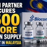 YouTube thumbnail announcing Biocon's partner securing a ₹500 crore insulin supply contract in Malaysia, featuring insulin vials, syringe, Biocon branding, and the Malaysian flag with the Petronas Twin Towers in the background.
