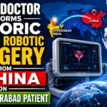 YouTube thumbnail showing a robotic surgery setup with advanced surgical robot arms operating on a patient. A digital world map highlights a connection between China and India, emphasizing a historic remote robotic surgery. Large bold text reads: "INDIAN DOCTOR PERFORMS HISTORIC REMOTE ROBOTIC SURGERY FROM CHINA ON HYDERABAD PATIENT."