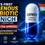 YouTube thumbnail featuring a large futuristic Zaynich antibiotic capsule with the Indian flag, US FDA approval seal, laboratory glassware, and microscope on a blue scientific background highlighting India's first indigenous antibiotic approved by the US FDA.
